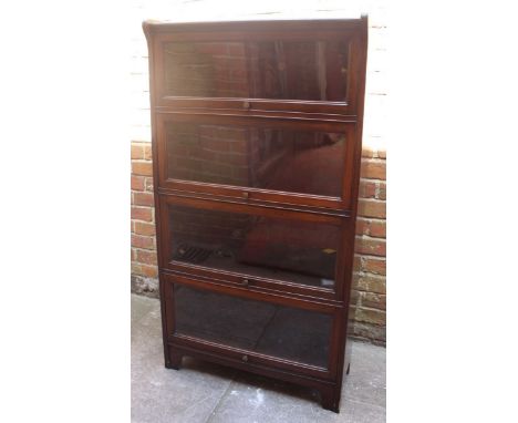 A four-section Globe Wernicke 'style' stained mahogany bookcase with glazed up-and-over doors  