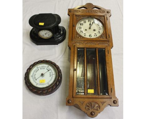 A 1930s oak wall clock, together with a carved oak aneroid barometer, and a Victorian black slate mantel clock. (3)