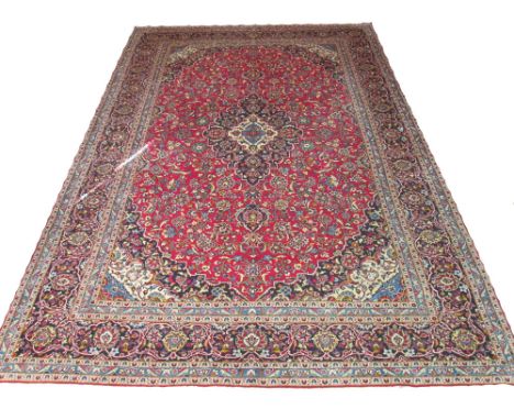 KASHAN CARPET, 435cm x 288cm, sapphire medallions on a terracotta field of palmettes and scrolling vines inside a correspondi