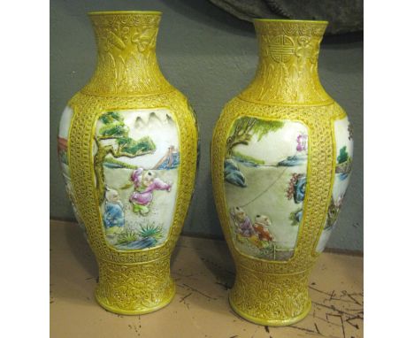 ORIENTAL CERAMIC VASES, a pair, decorated figure scenes in panels on a yellow ground, each 43cm H. (2)