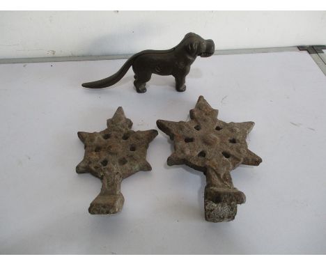 Two cast iron roof finials, along with a novelty cast iron nut cracker in the form of a dog