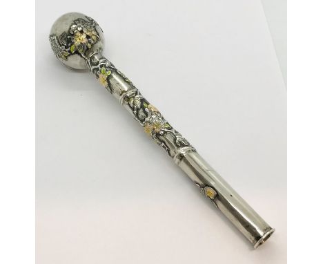 A Chinese silver parasol handle decorated in enamel with floral design 