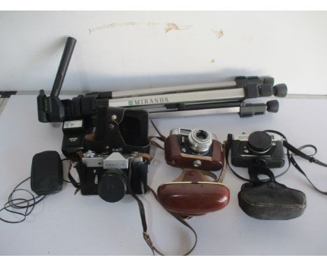 A collection of three vintage camera including Voigtlander, Zenit and Ricoh, along with a tripod etc