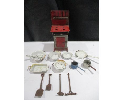 A collection of dolls house items including cooker, enamelled cookware and cast iron garden tools