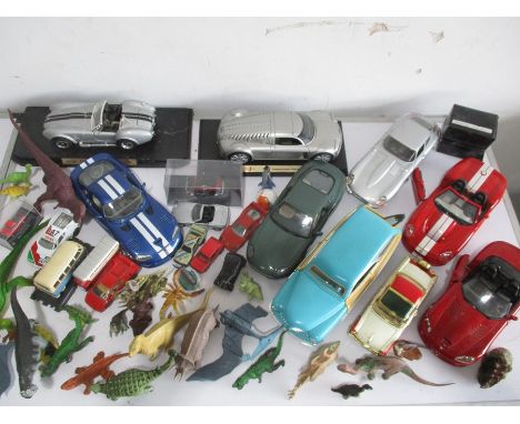 A collection of toy cars including Burago sport car, Maisto etc, along with a selection of toy dinosaurs