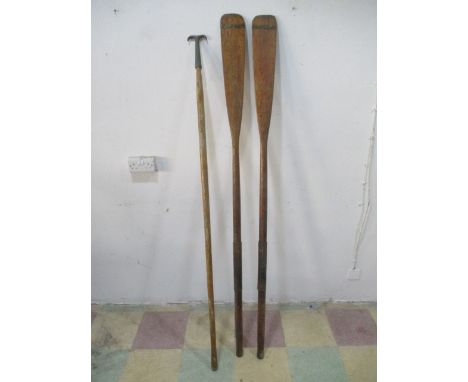 A pair of vintage wooden boat oars, along with a boat hook