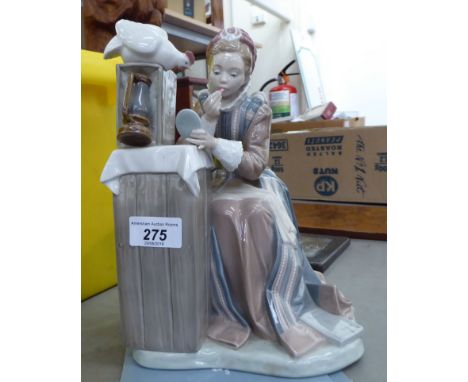 A Lladro porcelain figure, a woman wearing period costume beside a pedestal  10''h       F