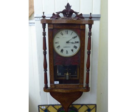 An early 20thC ebony and satinwood inlaid walnut wall clock; the movement faced by a Roman dial, inscribed 'Kay &amp; Comb**,