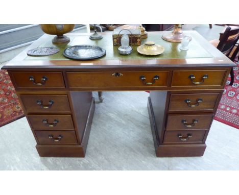 A modern mahogany finished nine drawer twin pedestal desk, raised on bracket feet  30''h  48''w      RAF