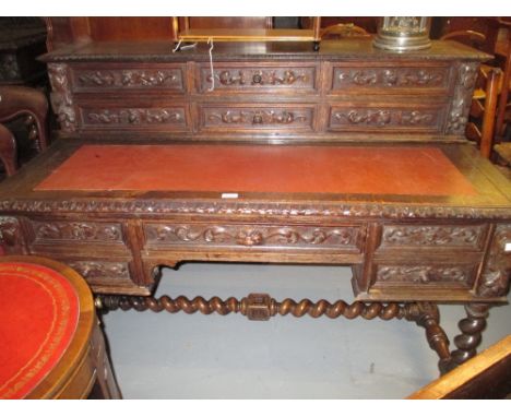 Victorian carved oak writing desk, the superstructure with six drawers above a lined writing surface with four mask head draw