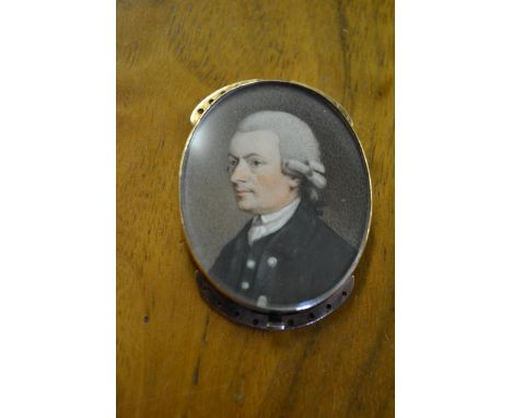 19th Century oval miniature head and shoulder portrait of a bewigged gentleman in a blue overcoat with white collar, in a yel