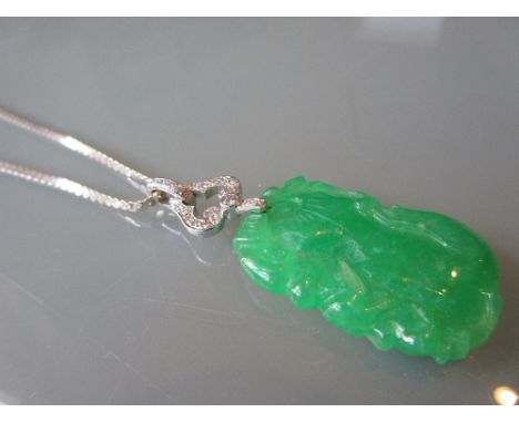 Carved jade and diamond set pendant mounted in white gold, suspended from a silver chain