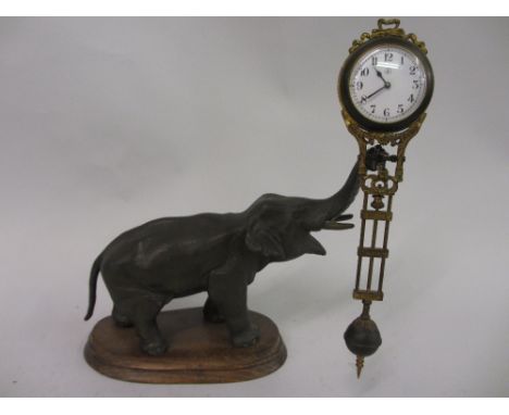 Dark patinated spelter mystery clock in the form of an elephant, the enamel clock dial with Arabic numerals in a dark patinat