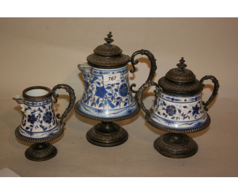W.M.F. electro plate mounted porcelain three piece tea service decorated in blue and white with stylised flowers (the teapot 