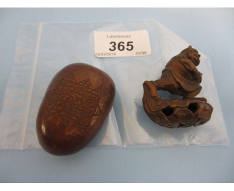 Japanese carved wooden netsuke in the form of a running man, together with oriental carved nutshell
