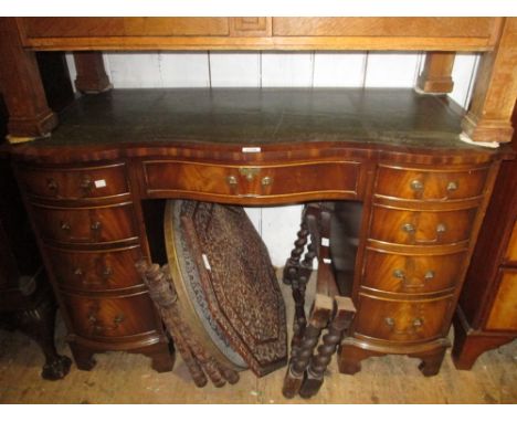 Reproduction mahogany serpentine fronted desk having green leather inset top above an arrangement of nine drawers with brass 