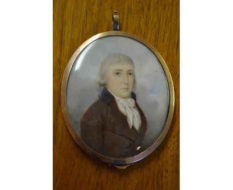 Early 19th Century oval head and shoulder portrait miniature of a gentleman in a red overcoat with blue collar, in a gold pla