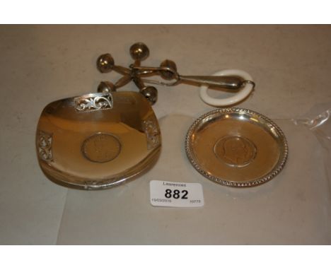 Two small Indian silver trinket dishes with coins together with a Continental silver babies rattle