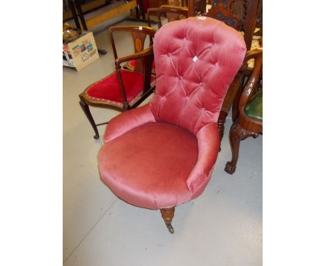 Victorian pink button upholstered low seat nursing chair on turned tapering supports with brass caps and casters