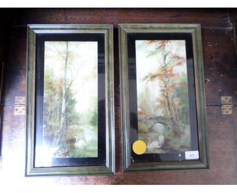 Pair of green and gilt framed rectangular coloured prints each of a pair of swans in forest side stream bordered by silver bi
