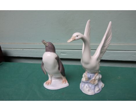 Lladro figure of  a penguin and a Nao figure of an alighting swan