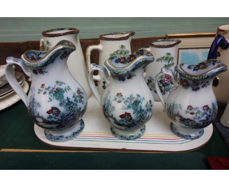 3 Decorative swan china graduated jugs and a further set of three graduated oriental patterned light blue ground jugs