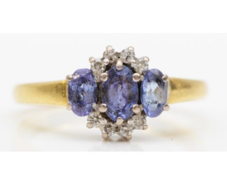 An 18ct gold three stone tanzanite and brilliant cut diamond ring, P, 4.5gm. 