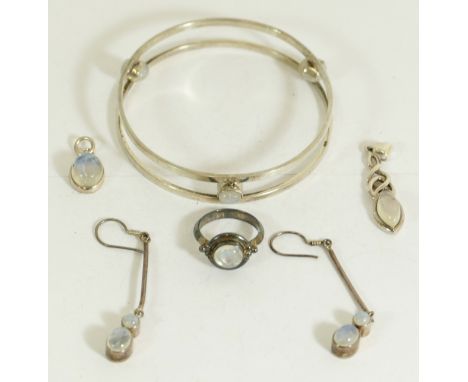 A silver and moonstone bangle, a pair of ear pendants, a pendant and a ring, 41gm 