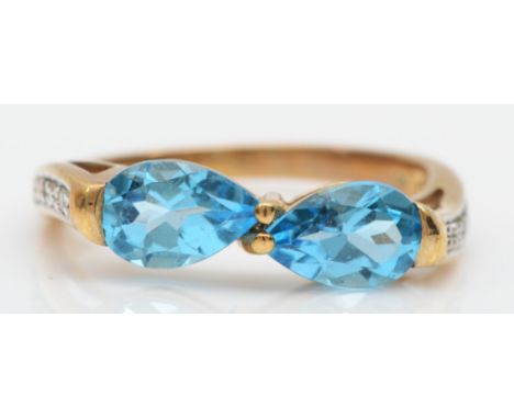 A 9ct gold two stone blue topaz ring, set with eight cut diamond shoulders, O, 2.6gm. 