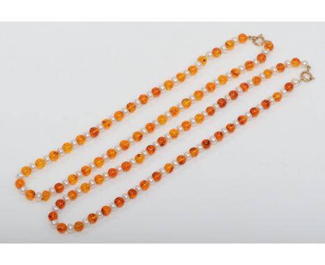 Two gold clasped amber and cultured pearl beaded necklaces, clasps stamped 375, 3 - 5mm beads, 24.1gm. 