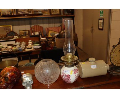 A willow pattern oil lamp with floral decorated shade 
