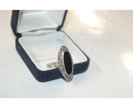 A silver ring set with black panel and marcasite surround 