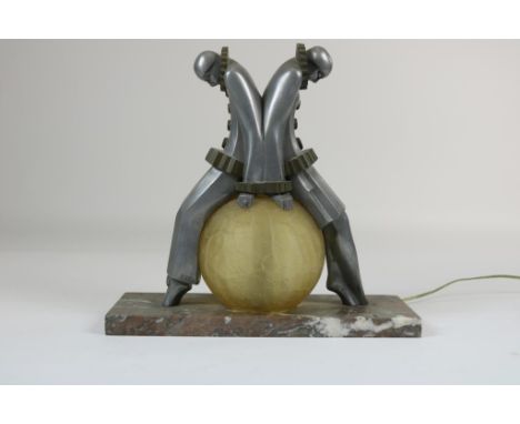 Art Deco table lamp with 2 pierrotsArt Deco tafellamp met 2 pierrots zittend op geelglazen bolkap,  h. 30, br. 31 cm.