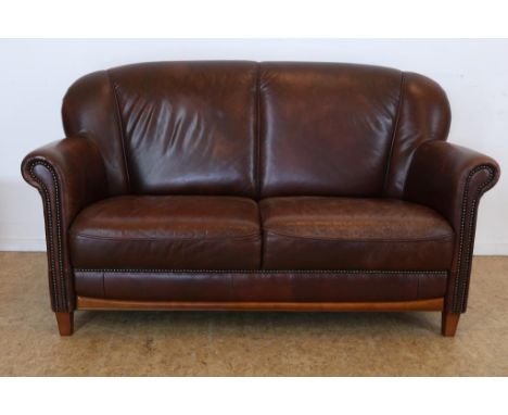 Brown leather 2 seater sofaBruinlederen 2 zits bank afgezet met siernagels op houten poten.