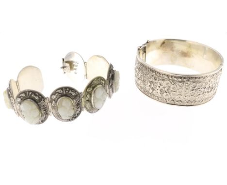 Two silver bracelets, one with carved white jade, China, and a hinged bracelet with daisies, 925/000, gross w. 90 gr., resp  
