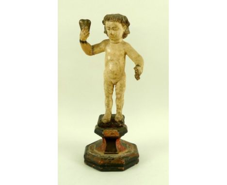 A carved wooden polychrome figure, possibly Spanish 18th century, modelled as a nude boy in standing pose, with curling hair,