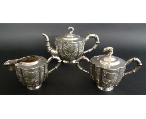 A Chinese Export silver three piece tea service, late 19th century, each of vertical fluted form with handles and tea pot spo