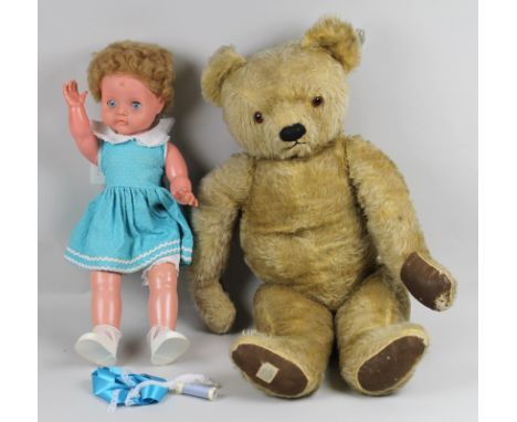 A vintage Chad Valley bear with jointed limbs, glass eyes and brown linen paws, 68cm long, together with a similarly aged dol
