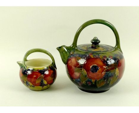 A Moorcroft Pomegranate pattern teapot with green ground, ovoid form, marked to the base in green, 19.5 by 20cm high, togethe