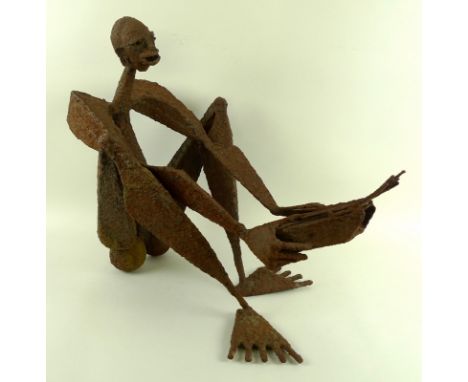 A rusted metal table sculpture, 20th century, modelled as a sitting musician with an African kaliba harp, reportedly from the