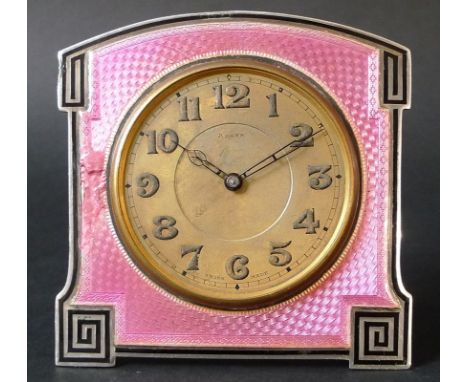 An Art Deco silver and enamelled travelling clock, the frame of arched square easel form, with line decoration framing a pink