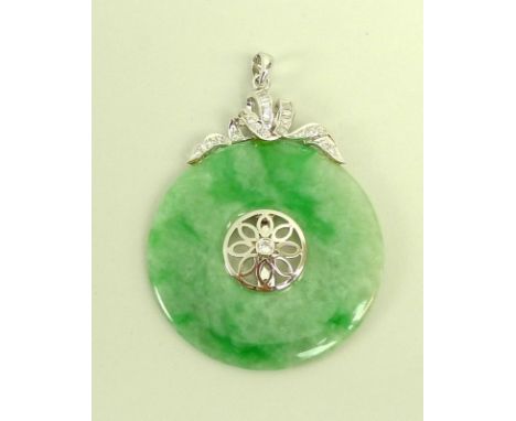 A jade and diamond pendant, the carved jade disc set centrally with floral design and brilliant cut diamond, with a ribbon de