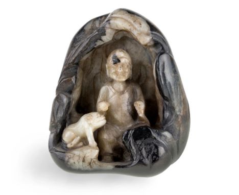 A Chinese grey and black jade carved pebble, Ming dynasty, 17th century, depicting a seated luohan in a cave beside a lion cu