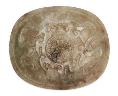 A Chinese celadon and mushroom jade 'wheel of dharma' oval plaque, 19th century, carved in shallow relief from a translucent 