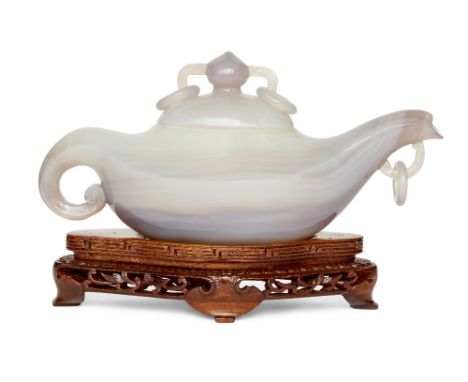 A Chinese agate teapot and cover, Republic period, of elongated form, the body carved from a single piece of stone with a fla