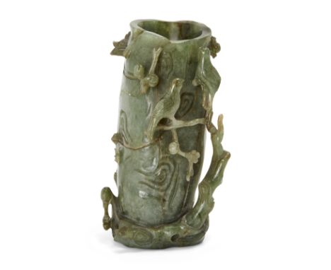 A Chinese dark green jade openwork brush pot, 19th century, carved as a gnarled trunk with birds perched on blossoming branch