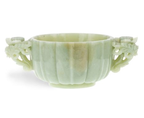 A large Chinese twin-handled celadon jade bowl, late Qing Dynasty/Republic period, standing on a short straight foot rising t