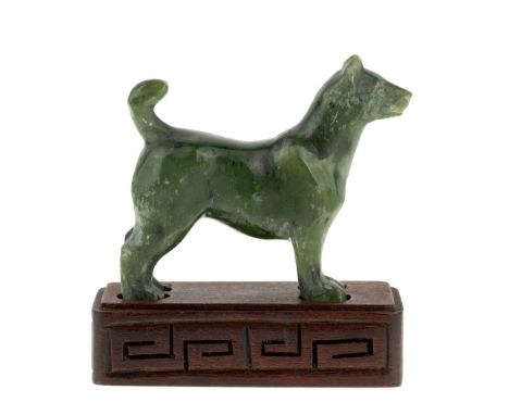 A Chinese spinach jade carved standing dog, early 20th century, carved standing on four legs with head extending forward, the