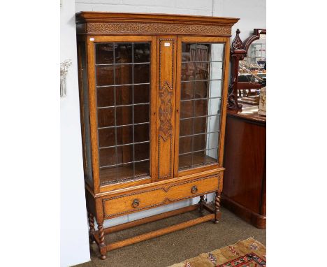 A 1920's oak bookcase with leaded glazed doors, 117cm by 30cm by 171cm, internal shelf depth is 24cm