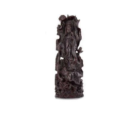 CHINESE GUANYIN CARVED FIGURE 20TH CENTURY posed with a walking stick, stood on and surrounded by a lotus leaf base, characte